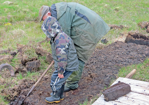 Photo of school-child trying peat cutting